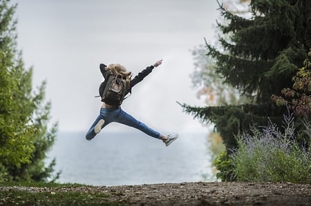 body-adventure-girl-jumping-backpack